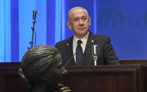 Israeli Prime Minister Benjamin Netanyahu stands behind a podium.