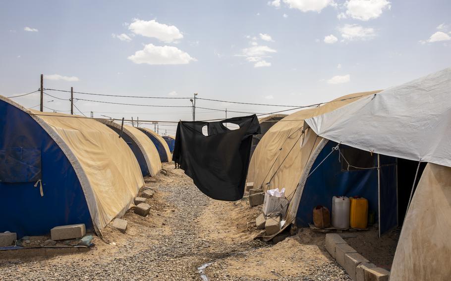 A washed veil dries outside a tent in the Jeddah camp, in Qayyarah, Iraq. 