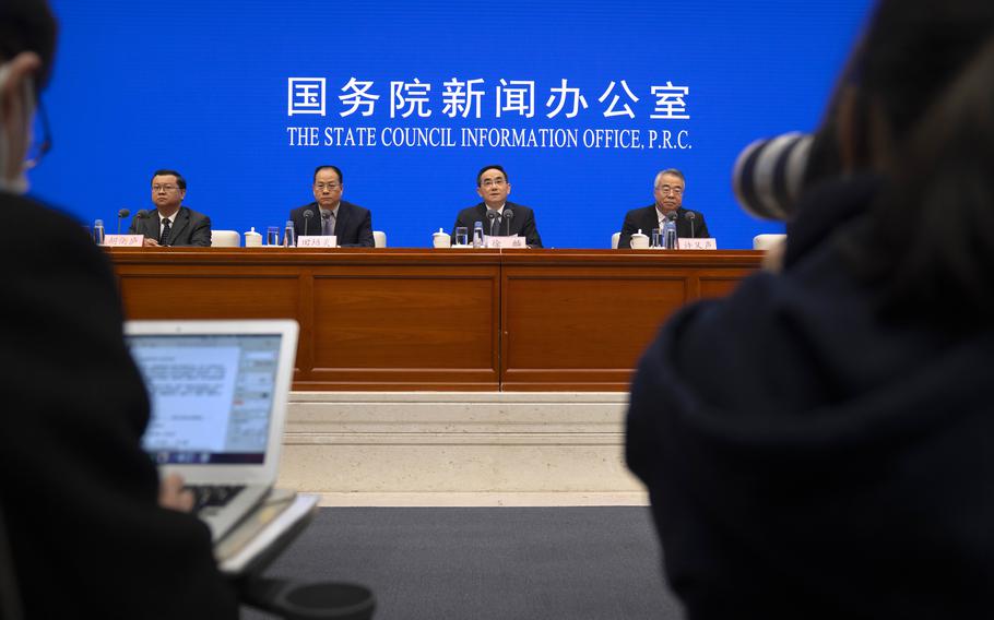 Officials attend a press conference at the State Council Information Office in Beijing, Saturday, Dec. 4, 2021. China’s Communist Party took American democracy to task on Saturday, sharply criticizing a global democracy summit being hosted by President Joe Biden next week and extolling the virtues of its governing system. 