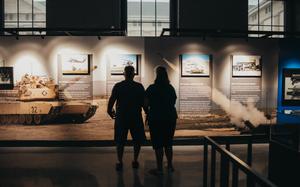 The silhouettes of two people looking at a museum display.