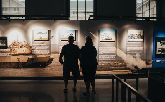 The silhouettes of two people looking at a museum display.
