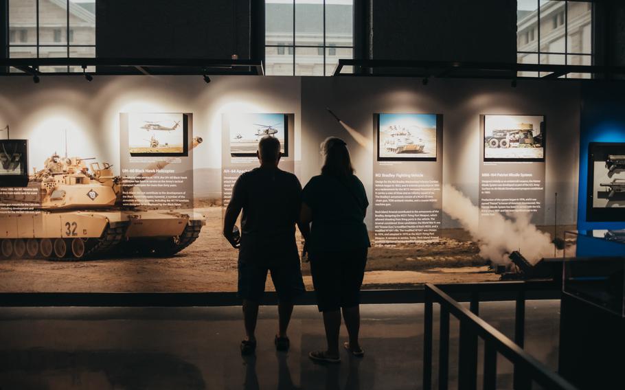 The silhouettes of two people looking at a museum display.