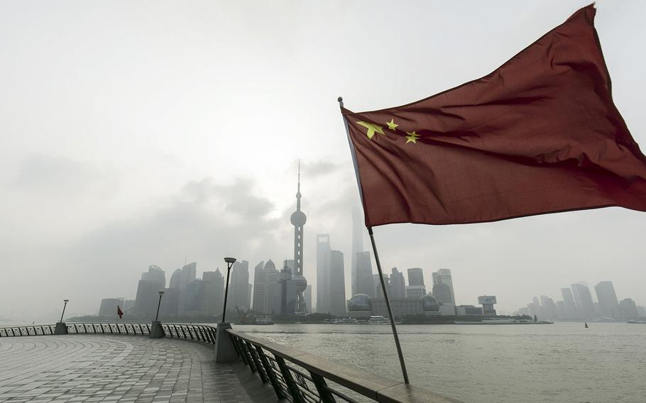 A Chinese flag in front of buildings in Pudong’s Lujiazui Financial District in Shanghai on Oct. 17, 2022. 