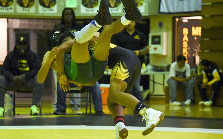 Kadena's Josiah Drummer sends Kubasaki's Jesse Fuentes airborne at 108 pounds during Wednesday's Okinawa wrestling dual meet. Drummer pinned Fuentes in 43 seconds, but the Dragons won the meet 39-26.