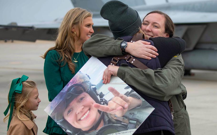 An aviator assigned to Strike Fighter Squadron (VFA) 37, “Ragin Bulls,” hugs a family member during a homecoming celebration.