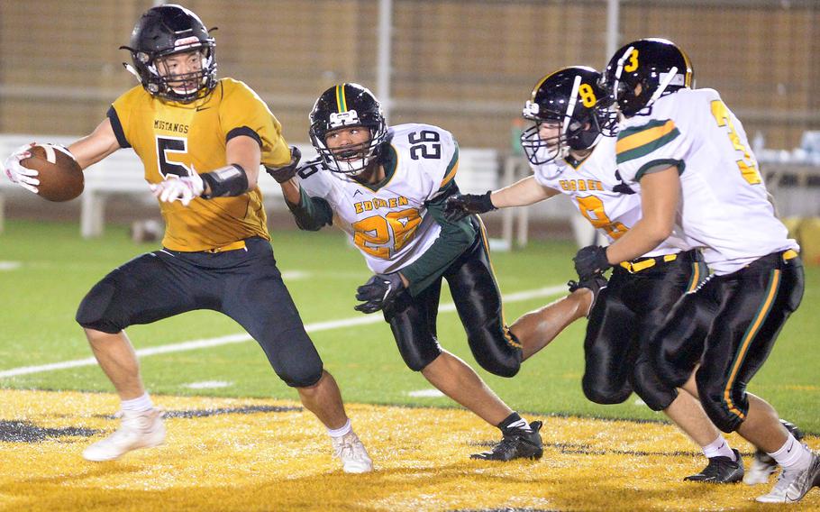 American School In Japan quarterback Joey Schulz tries to elude Robert D. Edgren defenders Noah Medonis, Daniel Phillips and Daichi Goodson.