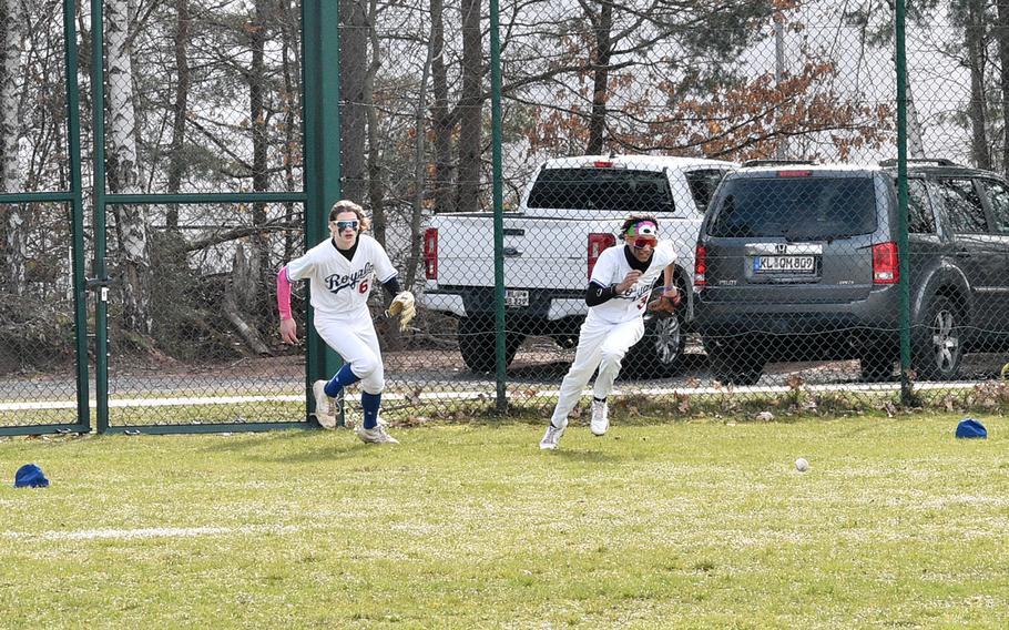 Ramstein outfielders Travis Ritz, left, and Christian Roy chase after a ball after it bounces off the fence during the first game of a Saturday doubleheader at the baseball field outside of Southside Fitness Center on Ramstein Air Base, Germany. The Royals tied the Panthers 8-8 after four innings.