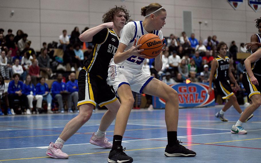 Ramstein's Kelan Vaugh backs down Stuttgart's Chris Hess during a basketball game on Dec. 8, 2023, at Ramstein High School on Ramstein Air Base, Germany.