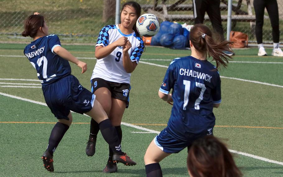 Osan's Clarice Lee plays the ball between two Chadwick defenders during Friday's Korea girls soccer match. The Dolphins and Cougars played to a 2-2 draw.
