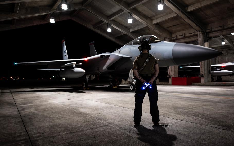 Senior Airman Allyssa Helman prepares to marshal an F-15D Eagle onto the flightline at Kadena Air Base, Japan, April 15, 2022. 