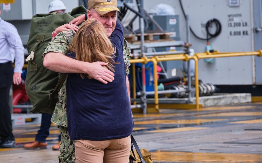 A sailor aboard the USS Ronald Reagan greets his spouse after the ship returned to Yokosuka Naval Base, Japan, on Oct. 16, 2021.