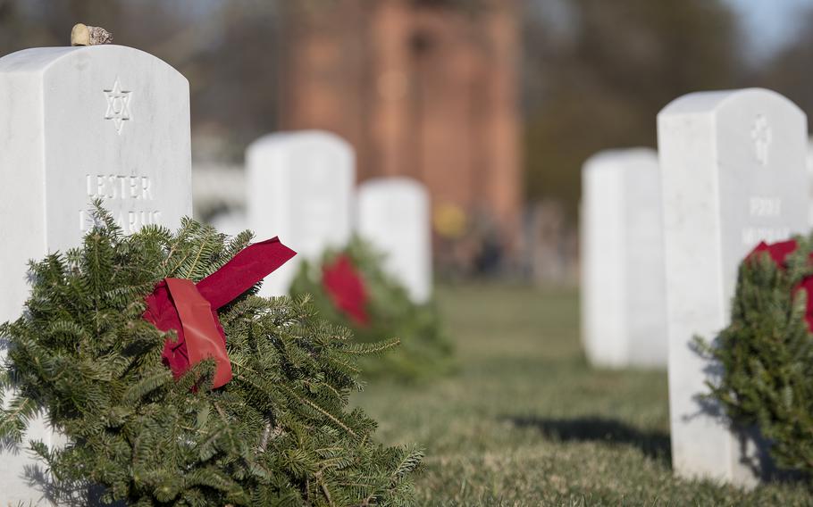 A wreath adorns the headstone of Korean War veteran Lester Lazerus at Arlington National Cemetery on Saturday, Dec. 17, 2022. Although a Star of David symbol is etched on the tombstone indicating Lazarus’ Jewish heritage, his daughter Wendy, who placed the wreath, said her Jewish father married “a beautiful Italian Catholic girl from the Bronx,” noting that their family celebrated Christmas every year when she was growing up.