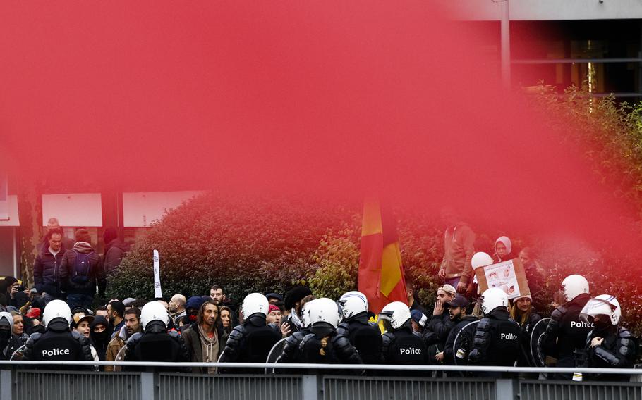 Police officers argue with protestors during a demonstration against the reinforced measures of the Belgium government to counter the latest spike of the coronavirus in Brussels, Belgium, Sunday, Nov. 21, 2021. Many among them also protested against the strong advice to get vaccinated and any moves to impose mandatory shots.