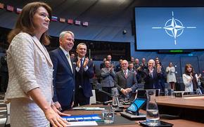 NATO Secretary-General Jens Stoltenberg, third from left, applauds July 5, 2022, after ambassadors signed the accession protocols for Finland and Sweden at NATO headquarters in Brussels. Swedish Foreign Minister Ann Linde, left, and Finnish Foreign Minister Pekka Haavisto stand next to him.