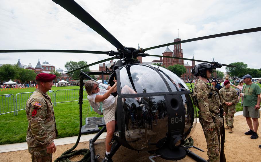 A woman gets in a helicopter as a soldier watches.