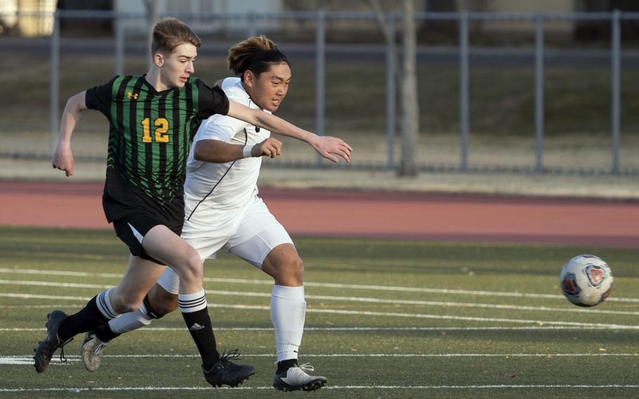 Robert D. Edgren’s Luke Lehner and Zama‘s Kaisei Muta chase the ball during Friday’s DODEA-Japan boys soccer match. The Trojans won 3-0.