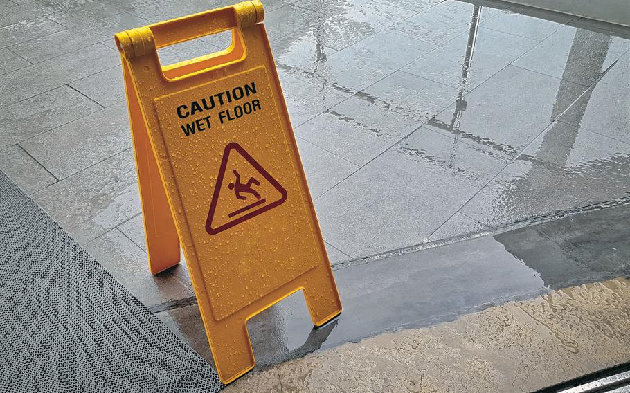 Yellow warning sign with the text Caution wet floor
