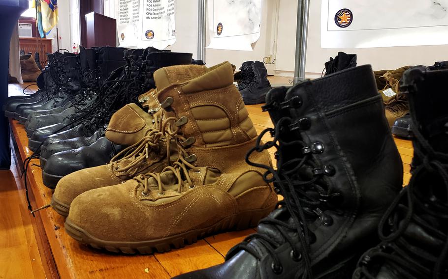 Pairs of boots representing fallen sailors are displayed during the Bells Across America ceremony at Yokosuka Naval Base, Japan, Thursday, Sept. 22, 2022. 