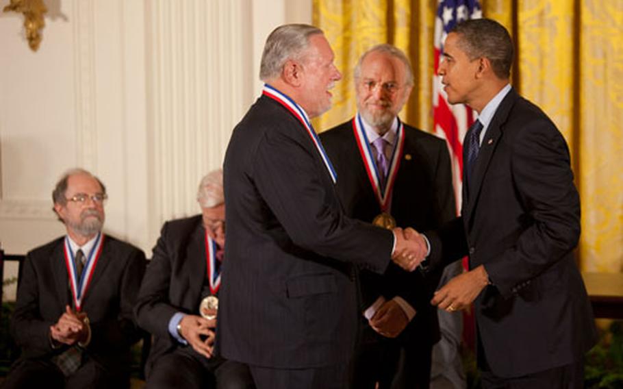 President Barack Obama congratulates Charles Geschke, left, and John Warnock, center, of Adobe Systems after presenting them with the National Medal of Technology and Innovation during an awards ceremony in the East Room of the White House, Oct. 7, 2009. 