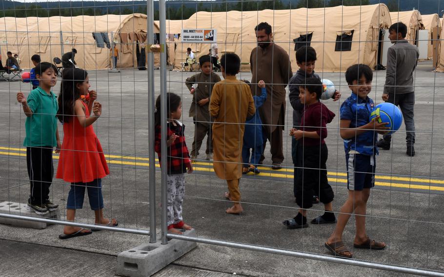 An Afghan boy flashes a smile Aug. 23, 2021, at Ramstein Air Base in Germany. Airmen handed children balls through the fence at the temporary living facilities for evacuees from Afghanistan.