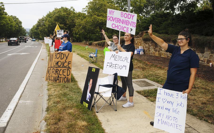 Brittany Watson, from left, Katie Hart, Dawn Carlisle and Amanda Mackanos demonstrate against employer vaccine mandates outside Winchester Medical Center in Winchester, Va., on Aug. 10, 2021.