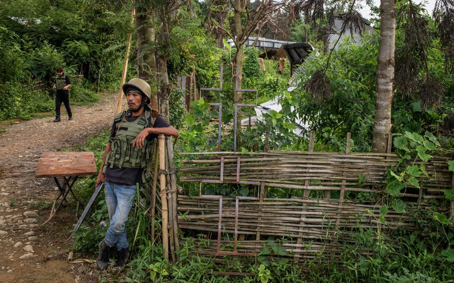 A defense volunteer stands in the village of Langza, where, according to accounts, the head of a decapitated 30-year-old Kuki named David Thiek was found earlier this year. 