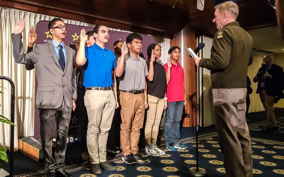 A group of new Army recruits take the enlistment oath during a launch event Wednesday, March 8, 2023, showcasing the service’s new marketing and recruiting campaign and the slogan, “Be All You Can Be,” at the National Press Club in Washington.