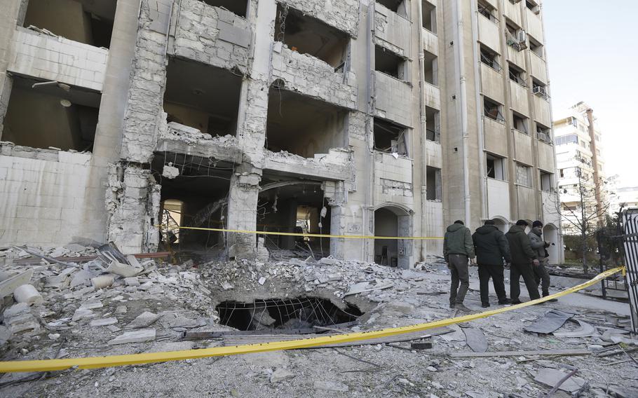 Syrian security officers inspect the damage in a residential neighborhood after an early morning Israeli airstrike in the capital city of Damascus, Syria, Sunday, Feb. 19, 2023. 