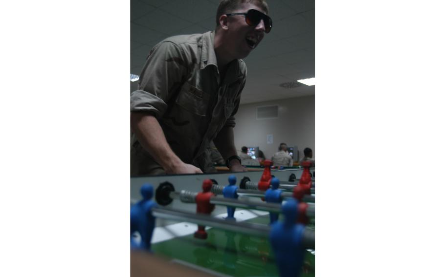 Marine Lance Cpl. Jon Maines, 21, an assaultman from Crofton, Md., plays foosball at Camp Lemonier near Djibouti City, Djibouti. The entertainment area on the 88-acre camp also has pool tables, video games, a bar and an Internet and phone center.