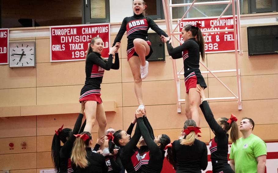 Lydia Kopko tops a human pyramid made by the American Overseas School of Rome’s cheer team at the 2023 DODEA-Europe Cheerleading Championships at Kaiserslautern High School on Friday, Feb. 18. AOSR placed first in the Division II team competition. 