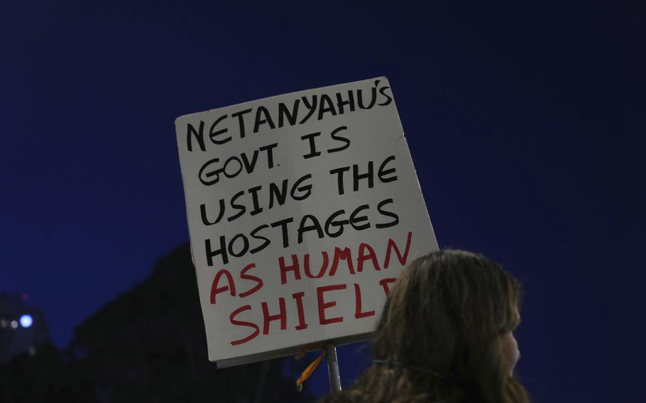 A protestor in Tel Aviv holds a sign that reads, “Netanyahu’s government is using the hostages as human shields.”