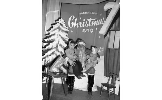 Frankfurt, Germany, Dec. 11, 1949: Charles 3, (left) seems a little less happy to see Santa than his 8-month old sister Elizabeth. The children of Sfc. and Mrs. Thomas Garefino, 24th Base Post Office did not want to entrust their Christmas wishes to the post office and came to whisper them into Saint Nick's ear themselves.

Check out Stars and Stripes' community sites to see if Santa will visit a base near you. https://ww2.stripes.com/communities

META TAGS: Europe; West Germany; holidays; Christmas; PX; Post Exchange; military family; children; boy; girl; Santa Claus