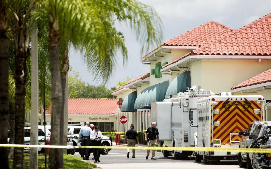 Police gather at the Publix shopping center at the scene of a shooting in Royal Palm Beach, Fla., on Thursday, June 10, 2021. Authorities say a shooting inside a Florida supermarket has left three people dead, including the shooter.