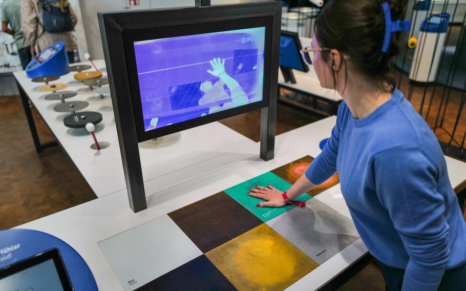 A visitor uses a heat camera to explore the conduction of heat and cold through different materials at the Experimenta Science Center in Heilbronn, Germany.