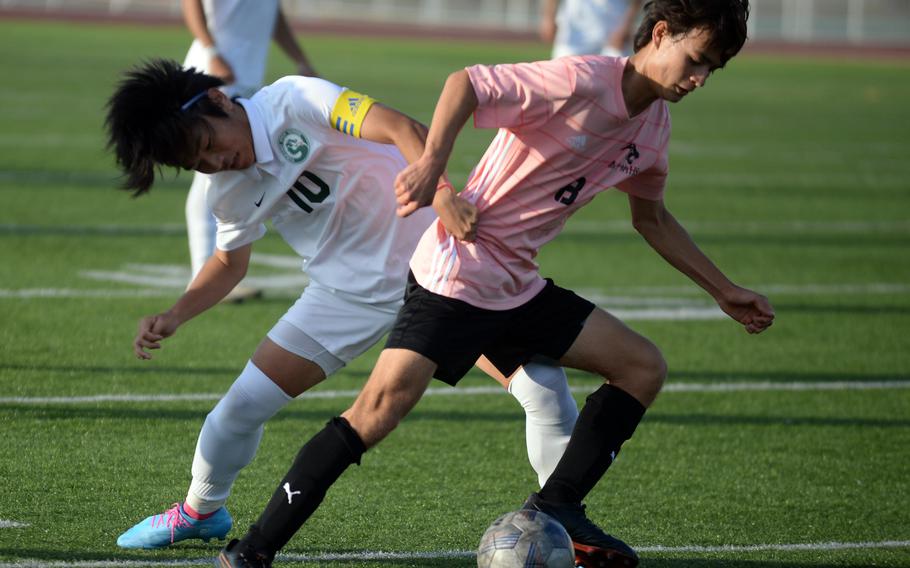 Kubasaki's Seira Fowler grabs a fistful of Kadena's Tuck Renquist's jersey as the two tangle for the ball during Wednesday's DODEA-Okinawa boys soccer match. The teams tied 0-0.