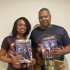 This photo provided by Black Sands Entertainment shows Manuel and Geiszel Godoy, founders of Black Sands Entertainment, with their flagship Black Sands comic book.  