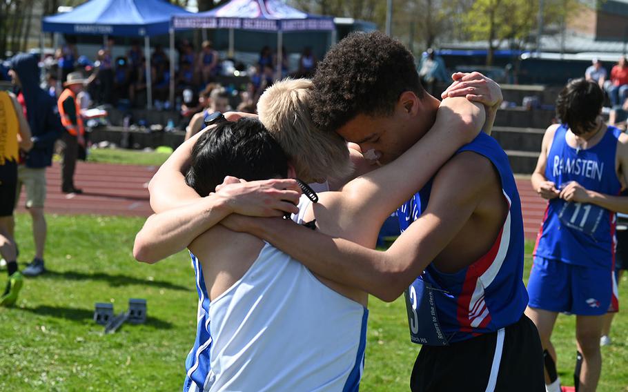 Tyrell Downs, right, a junior at Ramstein, embraces Luke Jones, center, and Nick Hernandez, both juniors at Wiesbaden, after competing in the mile during the Ansbach Invitational track meet at Ansbach Middle High School, Germany, on Saturday, April 6, 2024. Jones won the event with a time of 4:31.17. 