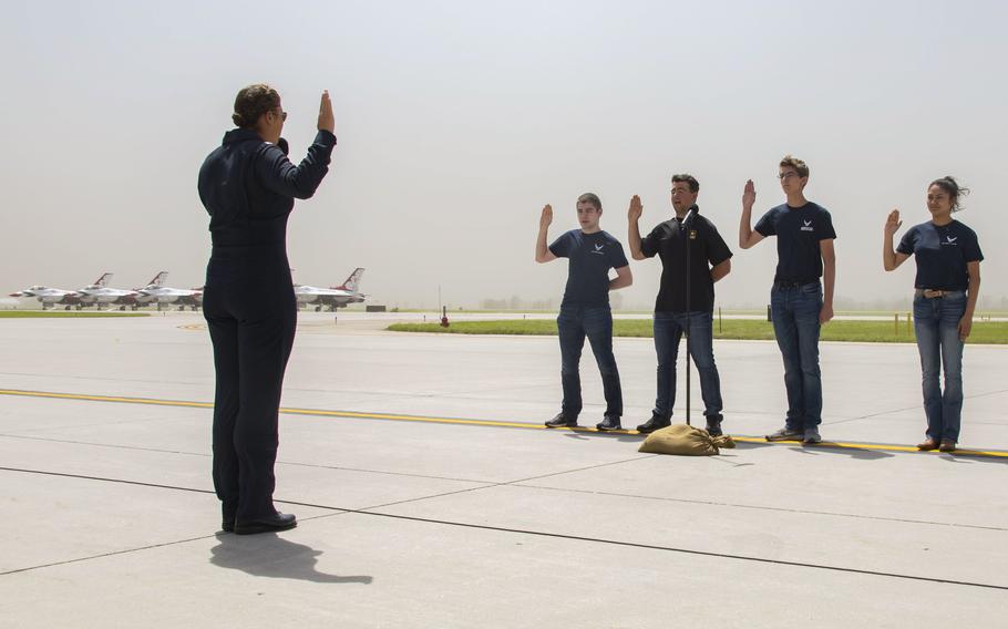 Maj. Katie Moorkamp, executive officer for Air Force Air Demonstration Squadron “Thunderbirds,” administers the oath of enlistment to Army and Air Force recruits June 18, 2022, during the Northern Thunder Air And Space Expo at Grand Forks Air Force Base, N.D. 