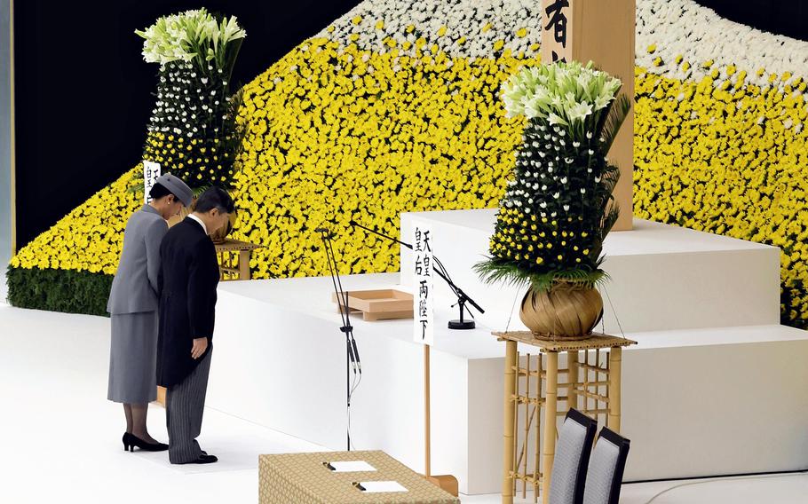 The Emperor and Empress observe a moment of silence at the annual memorial to mourn Japanese who died in World War II, at the Nippon Budokan hall in Tokyo on Tuesday.