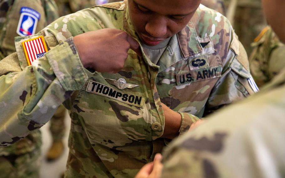 Spc. Marcus Thompson, a member of the 173rd Brigade Support Battalion, adjusts his German Parachutist Badge during a ceremony after jumping into Lake Constance, Germany, Friday, July 29, 2022.