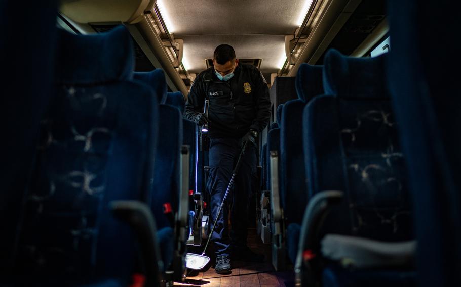 A U.S. Customs and Border Protection (CBP) officer inspects a bus from Mexico at the Laredo Port of Entry in Laredo, Texas, on Jan. 14, 2022. 