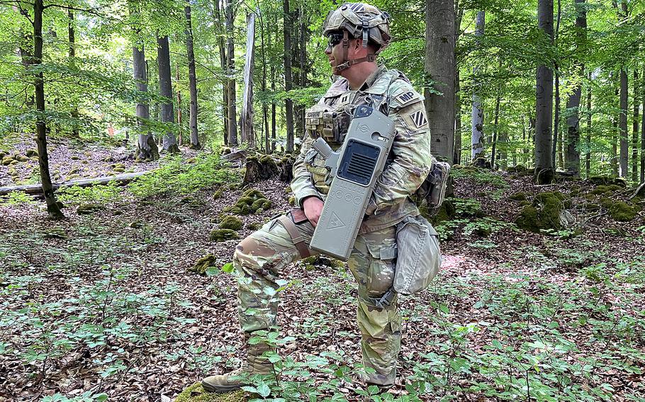 A soldier scans the wilderness while holding a Dronebuster jamming gun