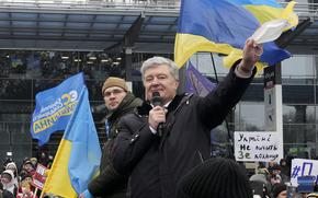 Former Ukrainian President Petro Poroshenko gestures while speaking to his supporters upon his arrival at Zhuliany International Airport outside Kyiv, Ukraine, Monday, Jan. 17, 2022. Poroshenko has returned to Ukraine to face court on treason charges he believes are politically motivated. At the Kyiv airport, where he arrived on a flight from Warsaw on Monday morning, Poroshenko was greeted by several thousand supporters. (AP Photo/Efrem Lukatsky)