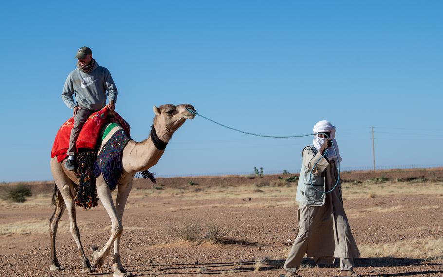 A U.S. airman rides a camel Dec. 2, 2023, during a women’s bazaar at Base 201 in Agadez, Niger. Area residents offered goods and services at the event to base personnel, whose patronage supported the local economy.