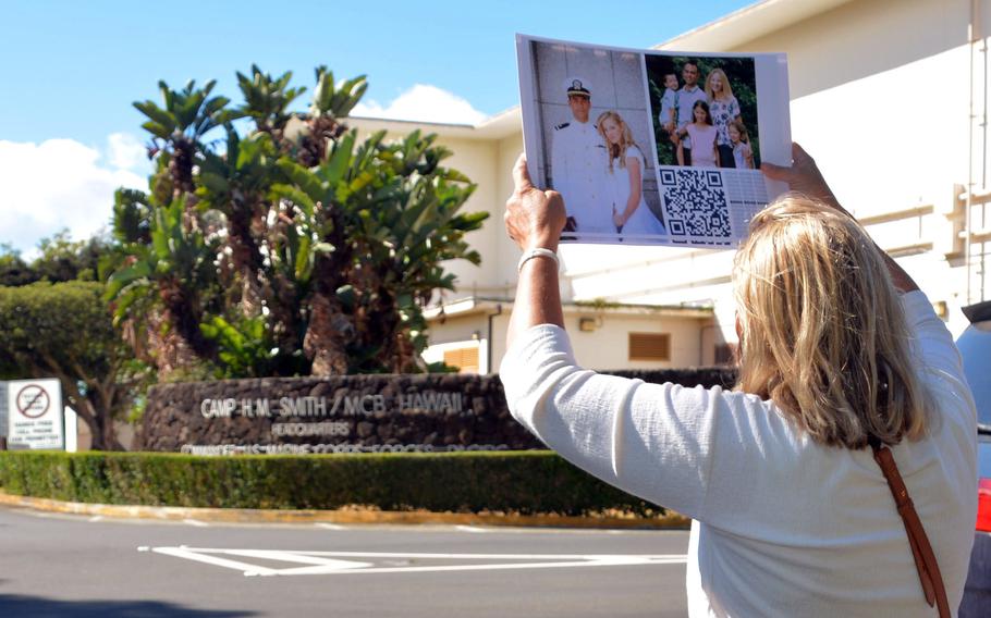 Lisa Hannemann holds up a sign in support of imprisoned Navy Lt. Ridge Alkonis outside the front gate of Camp H.M. Smith in Honolulu, Wednesday, Aug. 31, 2022.