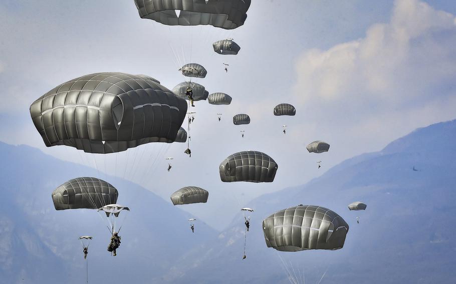 Parachutes fill the sky as Army paratroopers float to the ground during a jump.