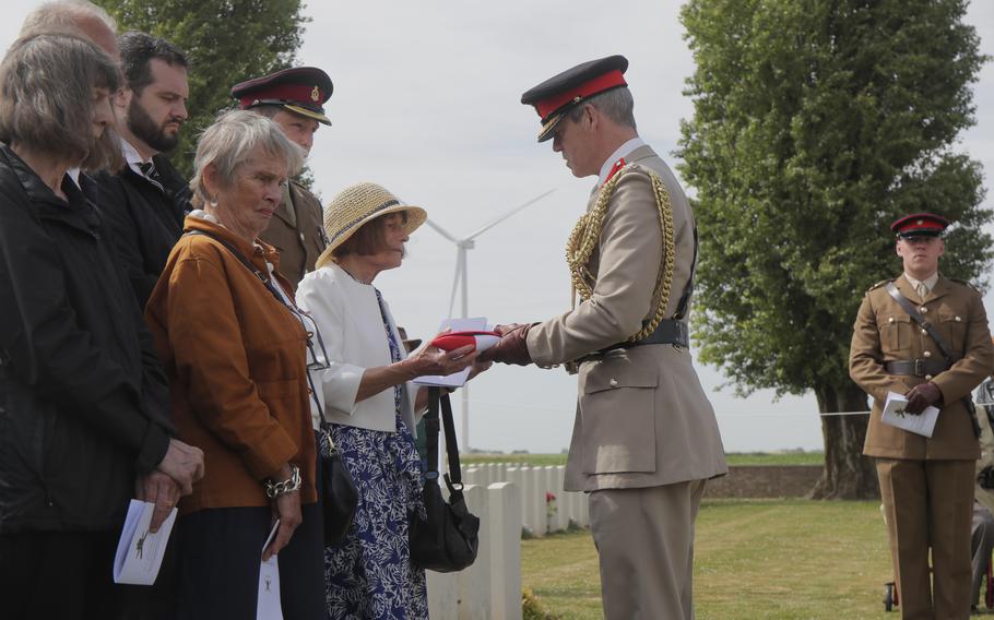 Colonel Howard Wilkinson, Military Attache, British Embassy Paris, gives a French flag to relatives during a Rededication Service for Second Lieutnant Osmund Bartle Wordsworth, in the cemetery of Ecoust-Saint-Mein, northern France, Tuesday, June. 21, 2022. Wordsworth was killed in action at the Battle of Arras on April 2, 1917. Second Lieutnant Jack Rice, 2nd Battalion The Royal Anglian Regiment stands at right.