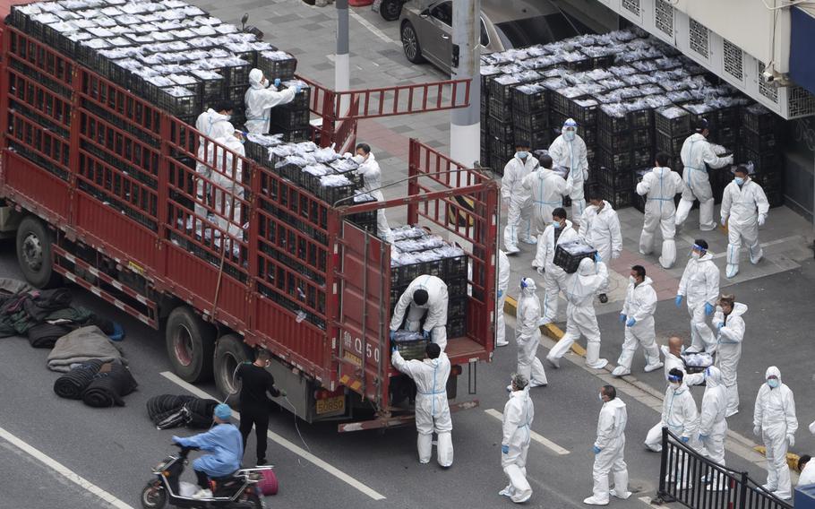 Workers in PPE unload groceries from a truck before distributing them to local residents under the COVID-19 lockdown in Shanghai, China on Tuesday, April 5, 2022. The COVID-19 outbreak in China’s largest metropolis of Shanghai remains “extremely grim” amid an ongoing lockdown confining around 25 million people to their homes, a city official said Tuesday.