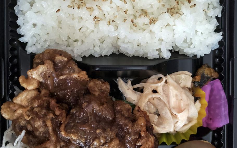 Akiruno City Rajikku's whale ginger lunch set comes with a large amount of white rice with pan fried meat on top. A small salad and pickles came with the meal.