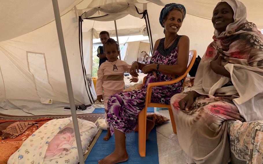 A woman with her newborn son, who was delivered by a Sudanese doctor working in a tent by the light of a telephone with only a razor blade to perform an episiotomy. 